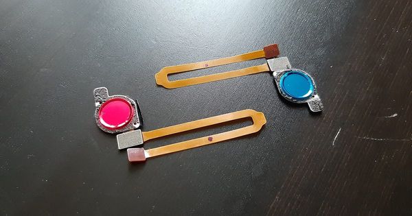Dos sensores de huella dactilar con su cable flexible sobre una mesa oscura